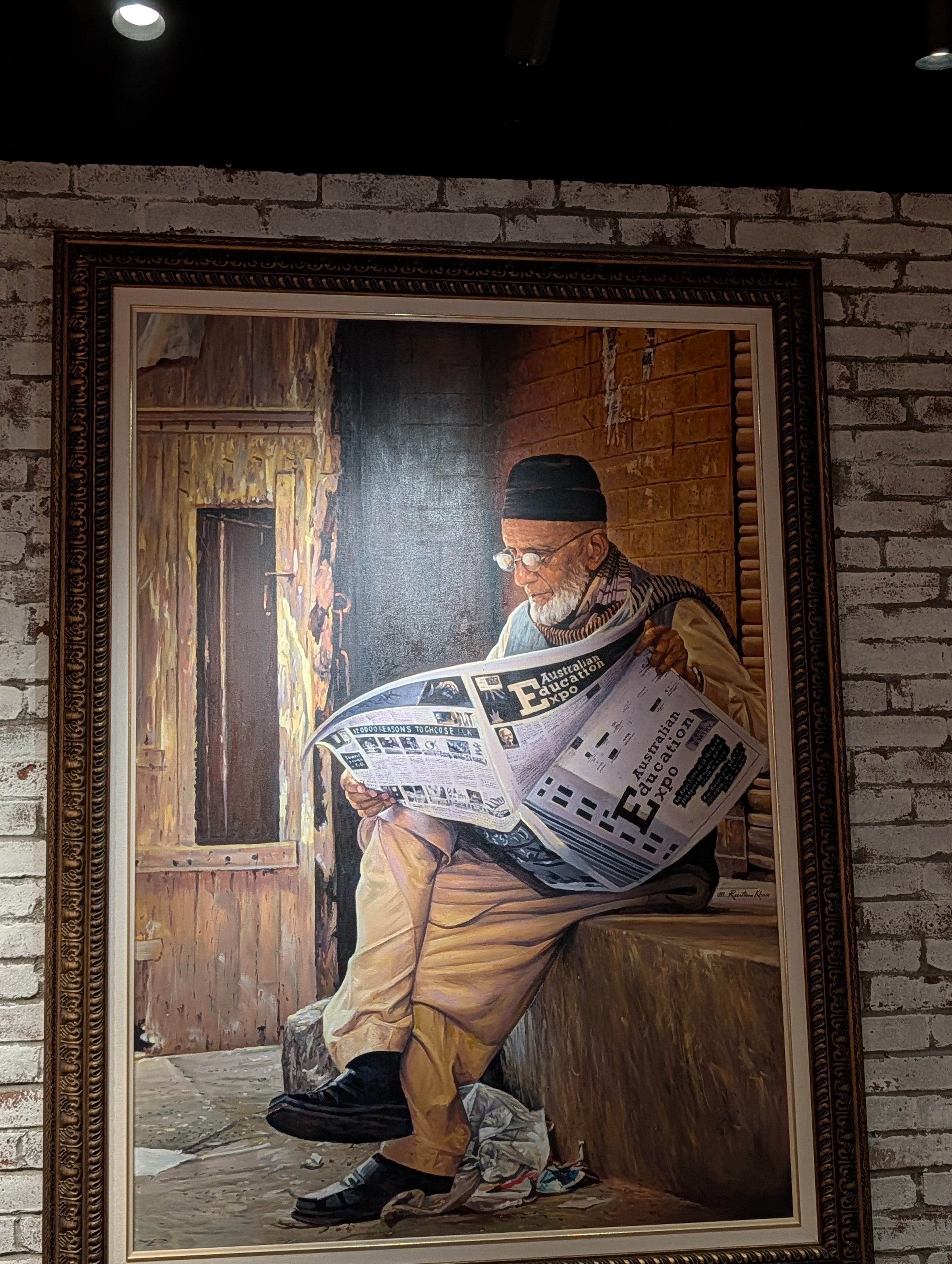 Framed painting of an elderly man reading a newspaper